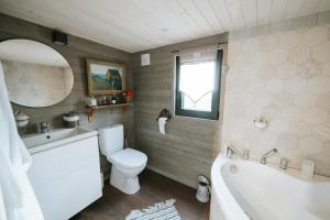 een badkamer met een bad, een toilet en een wastafel bij Berry Séjours in Malicornay
