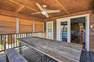 een veranda met een houten tafel en een plafondventilator bij Waterfront Guadalupe River Lodge Home with Dock! in Seguin