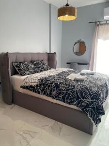 een slaapkamer met een bed met een zwart-wit dekbed bij Anais apartment in Preveza