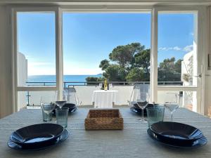 einen Tisch mit Tellern und Weingläsern sowie Meerblick in der Unterkunft La Terrazza sul Mare in Zoagli