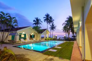 a villa with a swimming pool at night at Shangrela Beach Resort by ARK in Ambalangoda