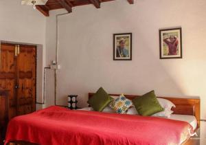 a bedroom with a bed with a red blanket at Fredy's Bungalow near Nainital in Bhīm Tāl