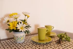 uma mesa com duas chávenas e um vaso de flores em Agriturismo Cappellese em Castelnuovo della Misericordia