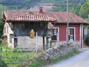 a small house with a stone wall next to a street at CASA ALDEA LOS CASTAÑOS in Triongo