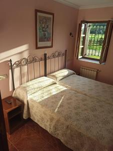 um quarto com uma cama grande e uma janela em CASA ALDEA LOS CASTAÑOS em Triongo
