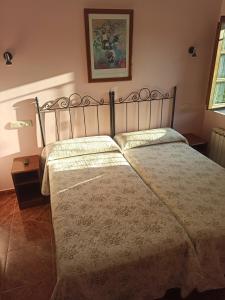 a bedroom with a large bed with a metal frame at CASA ALDEA LOS CASTAÑOS in Triongo