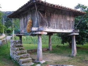 a bird feeder with a cat sitting on top of it at CASA ALDEA LOS CASTAÑOS in Triongo