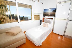 a bedroom with a bed and a couch and a window at Galeon Studio in Benidorm - Near the Beach in Benidorm