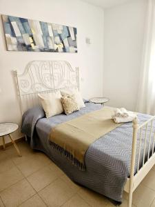 sypialnia z łóżkiem, dwoma stołami i obrazem w obiekcie Apartamento Exclusivo en Sevilla w Sewilli
