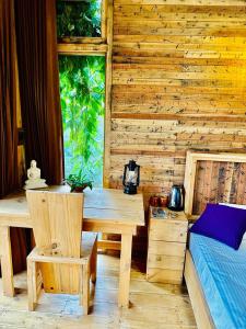 Holzzimmer mit einem Tisch und einem Bett in der Unterkunft Winwood Ella in Ella
