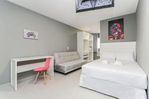 1 dormitorio con cama, escritorio y silla en Studios novos próximos ao shopping Beira-mar #HKS en Florianópolis