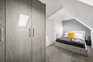 a bedroom with a bed and a large wooden cabinet at Fantastic Maidstone Flat - Sleeps 4 in Kent
