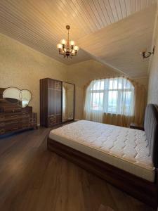 Un dormitorio con una cama grande y una lámpara de araña. en Shamakhi Villa en Şamaxı