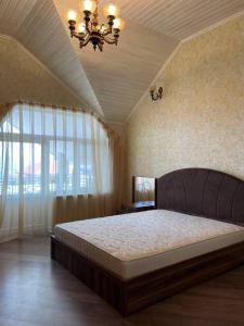 Un dormitorio con una cama grande y una ventana en Shamakhi Villa, en Şamaxı