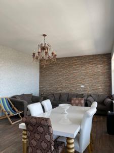 Shamakhi Villa في شاماكسي: غرفة معيشة مع طاولة بيضاء وأريكة