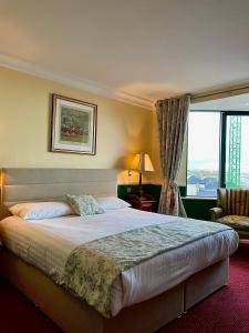 a hotel room with a large bed and a window at Reddans of Bettystown Luxury Bed & Breakfast, Restaurant and Bar in Bettystown