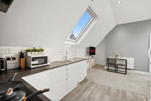 a kitchen with white cabinets and a large window at Fantastic Maidstone Flat - Sleeps 4 in Kent