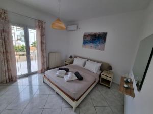 a bedroom with a bed with two towels on it at The Sunny Terrace House in Gournes