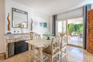 una sala da pranzo con tavolo e camino di Villa Mercuri a Alcudia