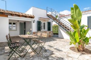 a patio with chairs and a staircase in front of a house at Villa Mercuri in Alcudia