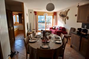 a dining table and chairs in a living room at Résidence Les Chardons Argentés in Samoëns