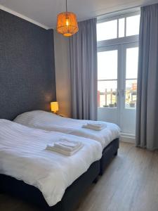 um quarto com uma cama e uma grande janela em De Molen em Zierikzee