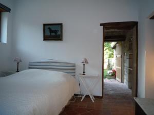 a bedroom with a bed and a door to a yard at Le Logis du Peu Girard in La Roche-Clermault