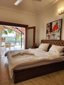 a large bed in a bedroom with a large window at Villa 17 Luisa by the Sea in Madgaon