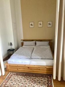 een bed met een houten frame in een slaapkamer bij Apartment Schloss Benrath in Greifswald