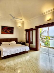 a bedroom with a bed and a large window at Villa 17 Luisa by the Sea in Madgaon