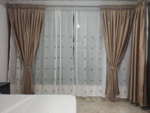 een slaapkamer met gordijnen en een bed in een kamer bij Apartamento el mirador in Melgar