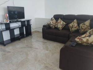 een woonkamer met een bank en een televisie bij Apartamento el mirador in Melgar