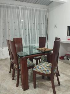 een glazen eettafel met stoelen en een glazen tafel en stoelen bij Apartamento el mirador in Melgar