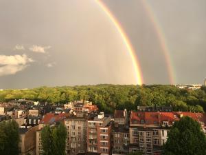 dois arco-íris sobre uma cidade com edifícios e árvores em Lovely View Ensuite Room em Bruxelas