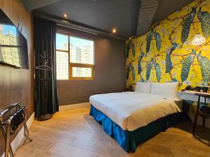 1 dormitorio con cama y pared amarilla en Modern Inn en Taichung