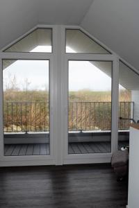 una veranda schermata con 2 finestre e un balcone di Haus Nr 23, Ferienhaus Deichgraf a Wangerland