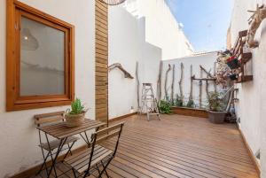 una terrazza in legno con tavolo e sedie. di Sant Rafel House ad Arenys de Mar