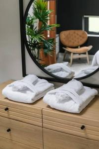 lustro siedzące na komodzie z białymi ręcznikami w obiekcie Three The Stables at Corrstown Village w mieście Portrush