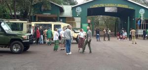 a group of people standing in the street near a bus at Karatu safari camp Lodge in Karatu