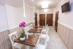 a dining room with wooden tables and white chairs at Hostel Zambrow in Zambrów