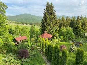 un giardino con gazebo e alberi di Cabana Perla Munților - Valea Doftanei a Podu lui Neag