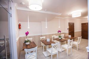 a dining room with wooden tables and white chairs at Hostel Zambrow in Zambrów