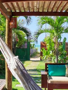 una hamaca en un patio con vistas al océano en La Villa Tropicale linda casa pertinho do mar !, en Icaraí