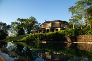 a house on a hill next to a body of water at Pristine Residence Iguazú in Puerto Libertad