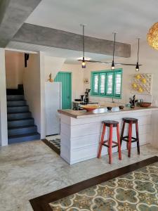 cocina con 2 taburetes y encimera en La Villa Tropicale linda casa pertinho do mar !, en Icaraí