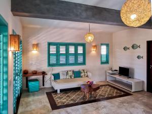 a living room with a couch and a tv at La Villa Tropicale linda casa pertinho do mar ! in Icaraí