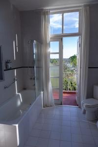 ein Bad mit einer Badewanne, einem WC und einem Fenster in der Unterkunft Pristine Residence Iguazú in Puerto Libertad