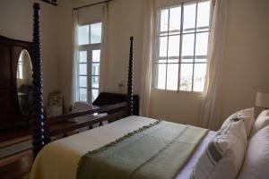 ein Schlafzimmer mit einem Bett und einem großen Fenster in der Unterkunft Pristine Residence Iguazú in Puerto Libertad