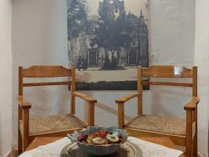 2 Stühle und eine Schüssel Essen auf dem Tisch in der Unterkunft Guesthouse Chryssoula in Chania