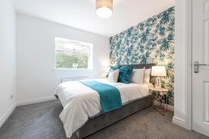 a bedroom with a large bed with blue and green wallpaper at Large 2-Bedroom Bungalow near Airedale Hospital, Keighley, Convenient Location with Parking in Steeton